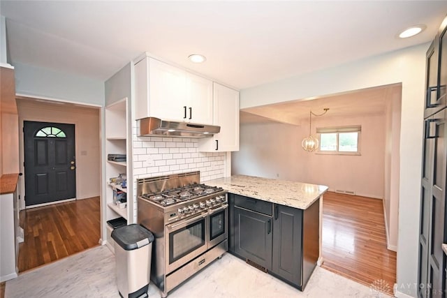 1525 Forrer Blvd, Kettering, OH 45420 - kitchen with range with two ovens, under cabinet range hood, white cabinets, a peninsula, and light stone counters