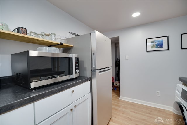 3227 Mirimar St, Dayton, OH 45409 - kitchen with stainless steel microwave, open shelves, light wood-type flooring, white cabinetry, and baseboards