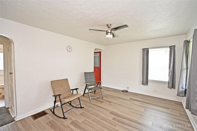 932 Crestmore Ave, Dayton, OH 45402 - unfurnished room with arched walkways, light wood-style floors, a ceiling fan, and a textured ceiling