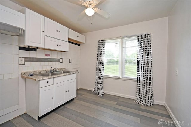 932 Crestmore Ave, Dayton, OH 45402 - kitchen featuring a sink, a ceiling fan, light wood finished floors, white cabinets, and light countertops
