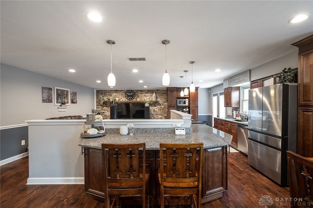 2155 Shenandoah Dr, Troy, OH 45373 - kitchen featuring appliances with stainless steel finishes, a spacious island, dark wood finished floors, light stone counters, and recessed lighting