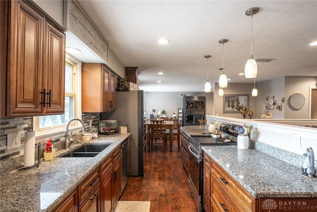 2155 Shenandoah Dr, Troy, OH 45373 - kitchen featuring appliances with stainless steel finishes, a sink, dark wood-style floors, decorative backsplash, and light stone countertops