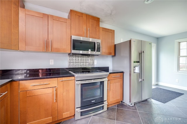 5894 Hamilton Lebanon Rd, Monroe, OH 45044 - kitchen featuring stainless steel appliances, dark countertops, dark tile patterned floors, and brown cabinets
