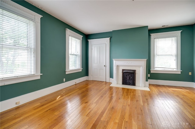 5894 Hamilton Lebanon Rd, Monroe, OH 45044 - unfurnished living room featuring hardwood / wood-style floors, healthy amount of natural light, a fireplace, and baseboards