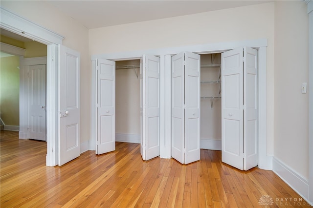 5894 Hamilton Lebanon Rd, Monroe, OH 45044 - unfurnished bedroom featuring multiple closets, light wood-style floors, and baseboards