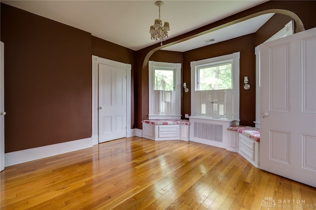 5894 Hamilton Lebanon Rd, Monroe, OH 45044 - foyer entrance with arched walkways, radiator heating unit, light wood finished floors, a chandelier, and baseboards