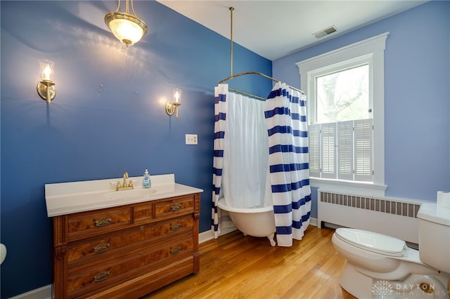 5894 Hamilton Lebanon Rd, Monroe, OH 45044 - full bath featuring radiator, toilet, wood finished floors, a shower with shower curtain, and vanity