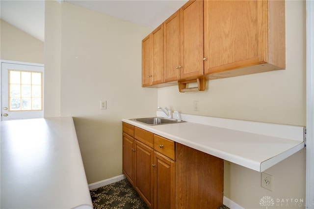5894 Hamilton Lebanon Rd, Monroe, OH 45044 - kitchen featuring a sink, baseboards, light countertops, vaulted ceiling, and brown cabinets