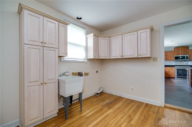 5894 Hamilton Lebanon Rd, Monroe, OH 45044 - washroom with hookup for an electric dryer, light wood-type flooring, cabinet space, and baseboards