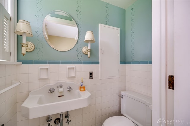 5894 Hamilton Lebanon Rd, Monroe, OH 45044 - bathroom featuring toilet, a sink, wainscoting, and tile walls