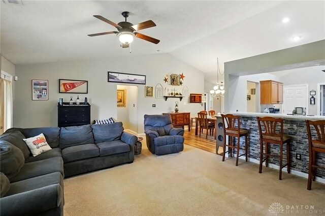 1248 Kern Dr, Germantown, OH 45327 - living area with lofted ceiling, light carpet, a ceiling fan, and a chandelier