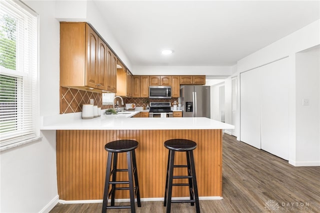 4513 Silver Oak St, Dayton, OH 45424 - kitchen with appliances with stainless steel finishes, a sink, a peninsula, backsplash, and dark wood-style flooring