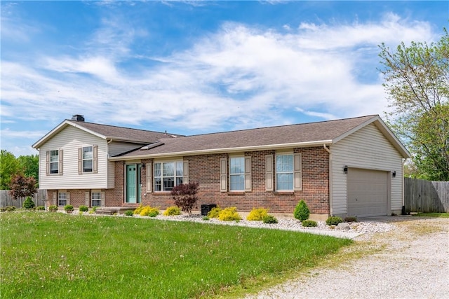 9673 Dayton Greenville Pike, Brookville, OH 45309 - tri-level home featuring an attached garage, brick siding, and driveway