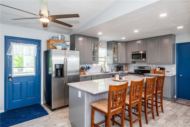 9673 Dayton Greenville Pike, Brookville, OH 45309 - kitchen with appliances with stainless steel finishes, gray cabinets, light wood-style flooring, a sink, and recessed lighting