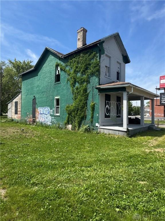 2300 E 3rd St, Dayton, OH 45403 - back of house featuring a chimney and a yard