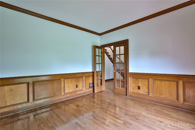 7299 Country Club Ln, West Chester, OH 45069 - unfurnished room with ornamental molding, a wainscoted wall, stairs, light wood-type flooring, and a decorative wall
