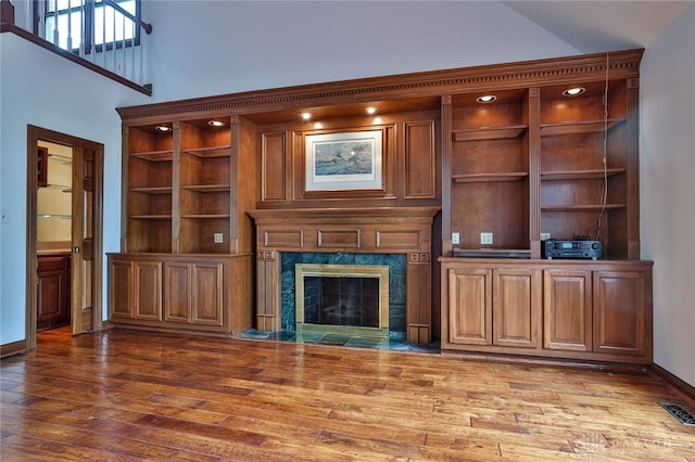 7299 Country Club Ln, West Chester, OH 45069 - unfurnished living room featuring wood finished floors, a high end fireplace, high vaulted ceiling, baseboards, and built in features