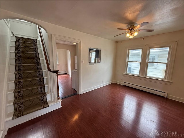 1805 Fauver Ave, Dayton, OH 45420 - empty room featuring arched walkways, a baseboard heating unit, a ceiling fan, and dark wood-style flooring