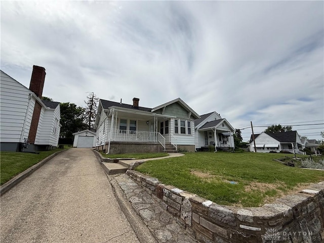 1805 Fauver Ave, Dayton, OH 45420 - view of front of property featuring a porch, asphalt driveway, an outbuilding, a garage, and a front yard