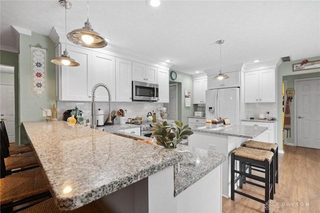 2866 Fence Stone Ct, Dayton, OH 45458 - kitchen with stainless steel appliances, a peninsula, a breakfast bar area, recessed lighting, and white cabinetry