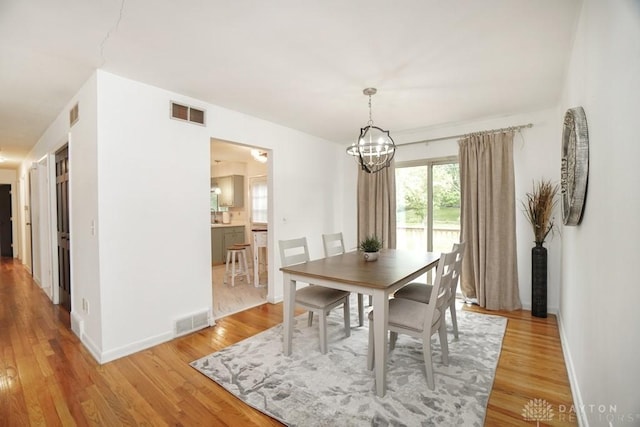 720 Boylston St, Middletown, OH 45044 - dining space with light wood-style floors, a chandelier, and baseboards