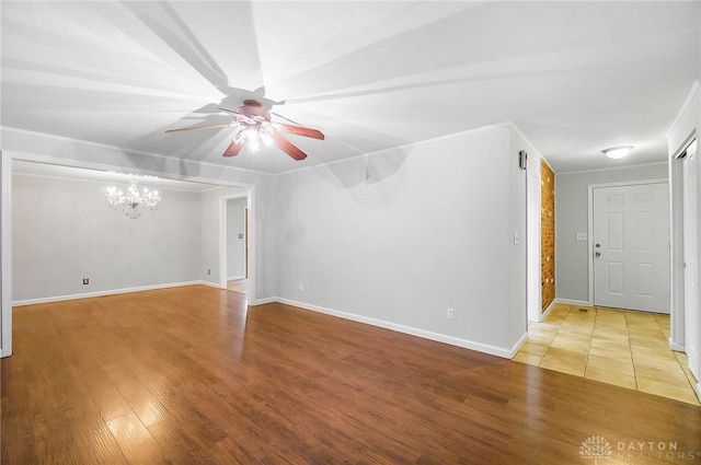 2765 Hemphill Rd, Kettering, OH 45440 - empty room with wood finished floors, a chandelier, ceiling fan, baseboards, and crown molding