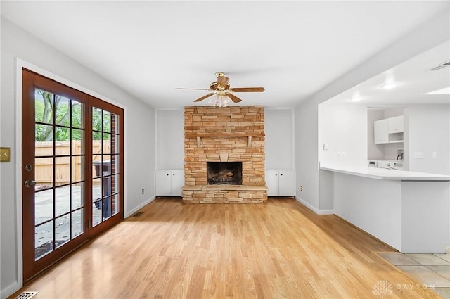 2765 Hemphill Rd, Kettering, OH 45440 - unfurnished living room with light wood finished floors, a ceiling fan, a stone fireplace, and baseboards