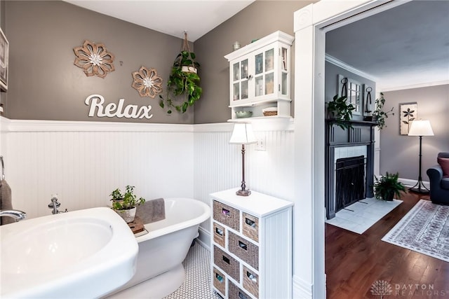 206 Wright Ave, Lebanon, OH 45036 - full bathroom featuring a wainscoted wall, a freestanding tub, wood finished floors, a fireplace with flush hearth, and a sink