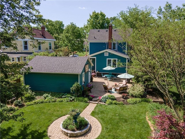 206 Wright Ave, Lebanon, OH 45036 - back of property featuring an outbuilding, a lawn, a patio, roof with shingles, and a chimney