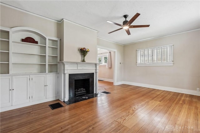 303 Hadley Ave, Oakwood, OH 45419 - unfurnished living room with ornamental molding, a ceiling fan, baseboards, hardwood / wood-style flooring, and a fireplace with flush hearth