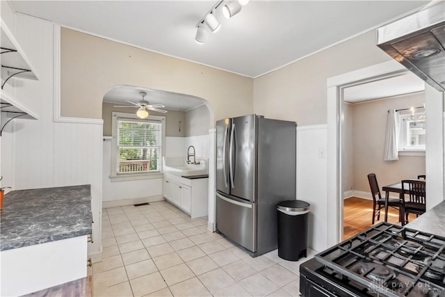 303 Hadley Ave, Oakwood, OH 45419 - kitchen with freestanding refrigerator, arched walkways, black gas range, white cabinets, and light tile patterned floors