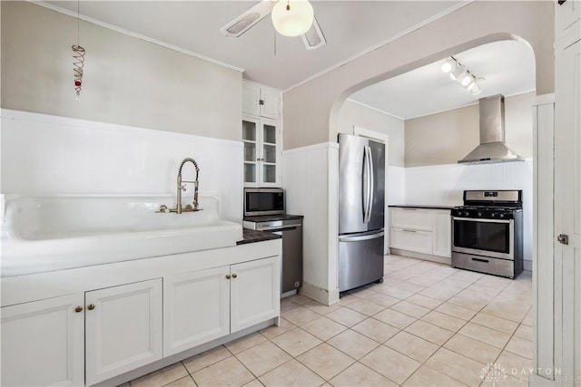 303 Hadley Ave, Oakwood, OH 45419 - kitchen with stainless steel appliances, wall chimney exhaust hood, arched walkways, white cabinetry, and light tile patterned flooring