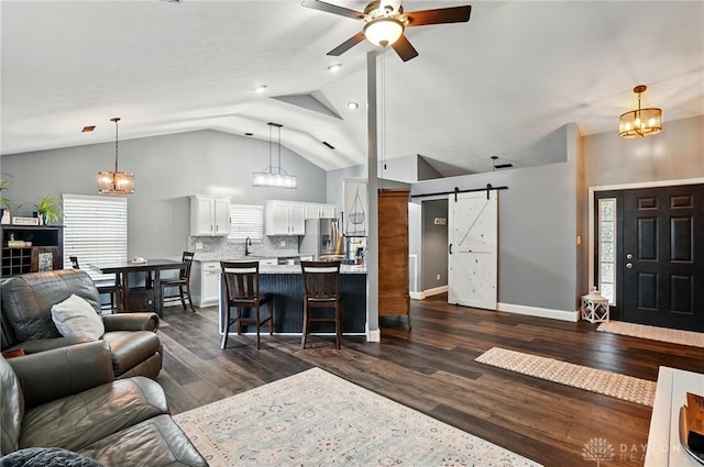432 Applegate Rd, Englewood, OH 45322 - living room featuring a barn door, vaulted ceiling, a ceiling fan, dark wood finished floors, and a chandelier