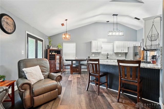 432 Applegate Rd, Englewood, OH 45322 - kitchen with stainless steel fridge, vaulted ceiling, a breakfast bar, white cabinetry, and dark wood-style floors