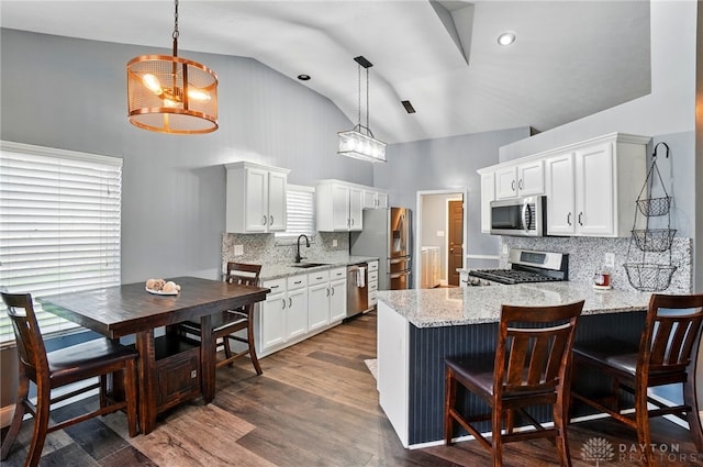 432 Applegate Rd, Englewood, OH 45322 - kitchen featuring appliances with stainless steel finishes, a sink, high vaulted ceiling, a peninsula, and tasteful backsplash