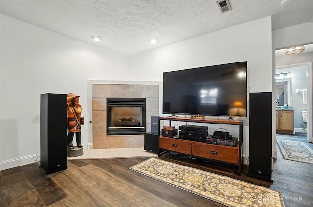 432 Applegate Rd, Englewood, OH 45322 - living area featuring wood finished floors, a tiled fireplace, a textured ceiling, baseboards, and recessed lighting