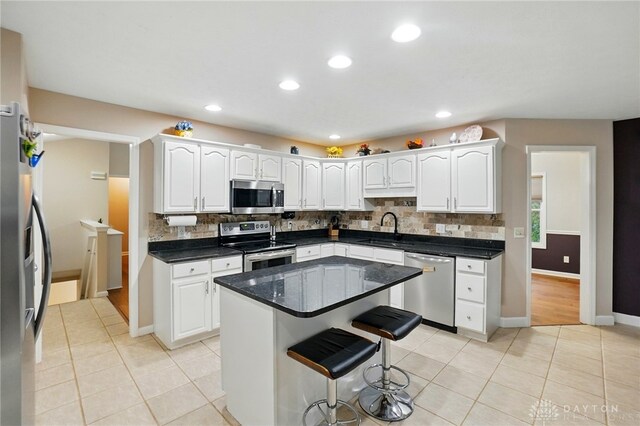 3835 Polo Trace Ct, Bellbrook, OH 45305 - kitchen with appliances with stainless steel finishes, a sink, backsplash, a kitchen bar, and white cabinets