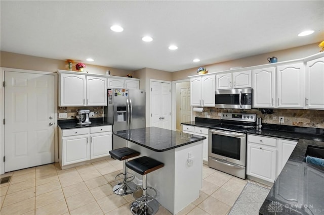3835 Polo Trace Ct, Bellbrook, OH 45305 - kitchen with appliances with stainless steel finishes, decorative backsplash, white cabinets, recessed lighting, and a center island