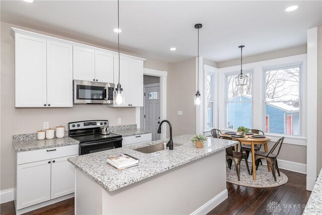 4370 Dayton Liberty Rd, Dayton, OH 45417 - kitchen with stainless steel microwave, black electric range, a sink, baseboards, and dark wood finished floors