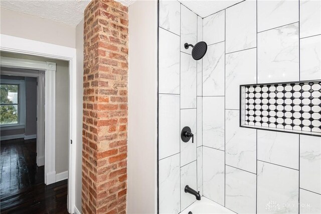 4370 Dayton Liberty Rd, Dayton, OH 45417 - bathroom with shower / bath combination, hardwood / wood-style floors, a textured ceiling, and baseboards