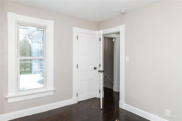 4370 Dayton Liberty Rd, Dayton, OH 45417 - unfurnished bedroom featuring baseboards, dark wood-style floors, and a closet