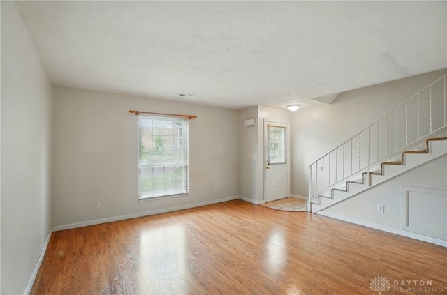 729 Clareridge Ln, Dayton, OH 45458 - unfurnished living room with plenty of natural light, wood finished floors, and stairs
