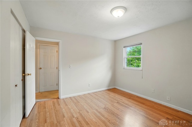 729 Clareridge Ln, Dayton, OH 45458 - empty room featuring light wood finished floors, baseboards, and a textured ceiling