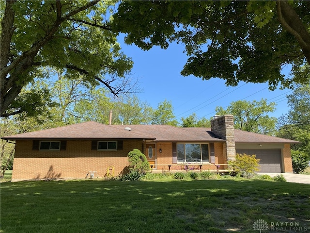 10520 Grand Vista Dr, Dayton, OH 45458 - ranch-style house with brick siding, a front yard, an attached garage, a chimney, and driveway