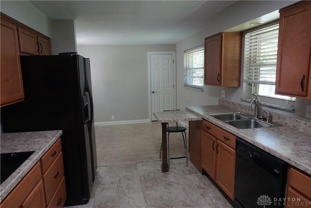 10520 Grand Vista Dr, Dayton, OH 45458 - kitchen with black appliances, a sink, brown cabinetry, baseboards, and light countertops