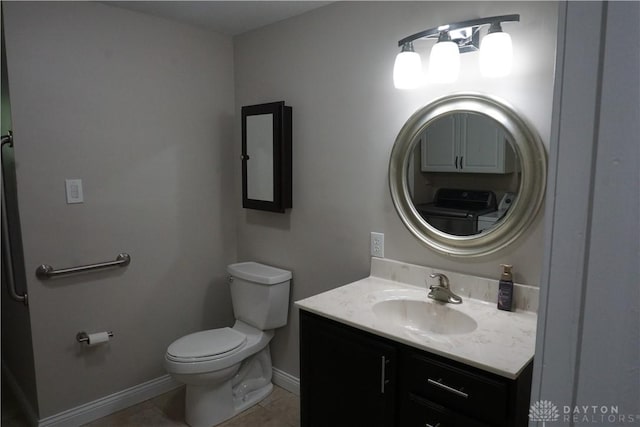 10520 Grand Vista Dr, Dayton, OH 45458 - bathroom featuring vanity, baseboards, toilet, tile patterned flooring, and washer / dryer