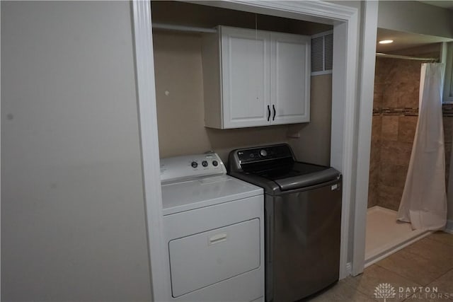 10520 Grand Vista Dr, Dayton, OH 45458 - laundry area featuring cabinet space, separate washer and dryer, and light tile patterned floors