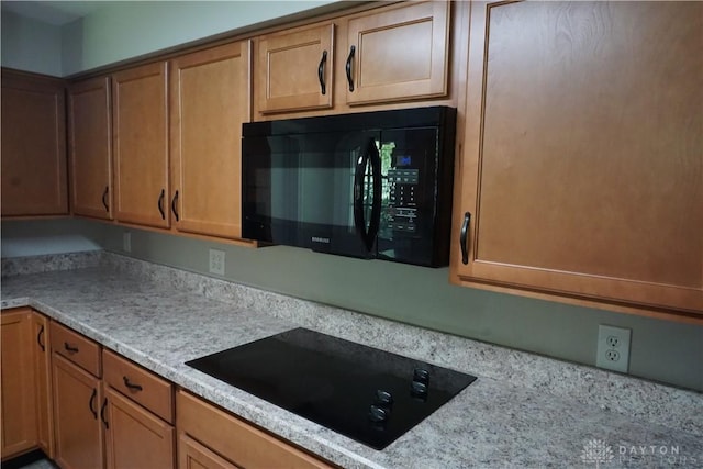 10520 Grand Vista Dr, Dayton, OH 45458 - kitchen featuring black appliances, light countertops, and brown cabinets