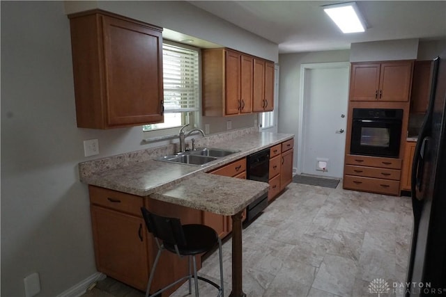 10520 Grand Vista Dr, Dayton, OH 45458 - kitchen featuring a sink, black appliances, brown cabinets, light countertops, and a peninsula