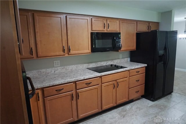 10520 Grand Vista Dr, Dayton, OH 45458 - kitchen with black appliances, light countertops, brown cabinetry, and light tile patterned flooring